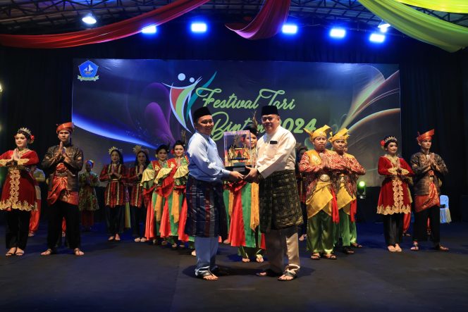 
					Sekda Bintan Ronny Kartika menyerahkan piala juara Festival Tari Tingkat Kabupaten Bintan di Relief Antam Kijang, Sabtu (27/7/2024) malam.