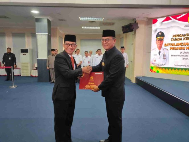 
					Pj Wali Kota Tanjungpinang Andri Rizal menyerahkan penghargaan Satyalancana Karya Satya tahun 2024 kepada PNS.