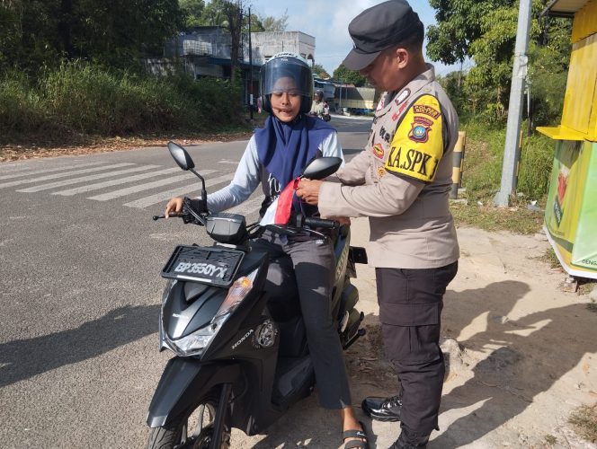 
					Personil Polsek Bintan Utara saat membagikan bendera merah putih kepada masyarakat pengguna jalan raya atau pengendara yang melintasi kawasan di jalan Taman Sari Simpang 4 Lampu Merah Tanjung Uban, Kamis (1/8/2024). 