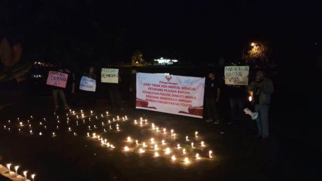 
					Aksi menerangi Taman Kota di Kijang, Kecamatan Bintan Timur, Bintan dengan 1000 lilin mengajak warga untuk menerangi pilkada 2024 tanpa kolom atau kotak kosong, Jumat (30/8) malam