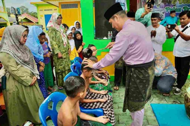 
					Pj Walikota Tanjungpinang Andri Rizal saat melakukan prosesi memandikan sepuluh anak yang menjadi peserta mandi Safar