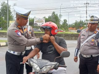 Kasatlantas Polres Bintan AKP Firudin, saat terjun langsung berikan helm gratis ke pengguna kendaraan roda dua, Senin (13/01/2025).