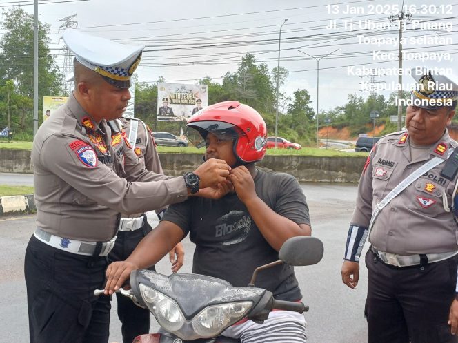 
					Kasatlantas Polres Bintan AKP Firudin, saat terjun langsung berikan helm gratis ke pengguna kendaraan roda dua, Senin (13/01/2025).