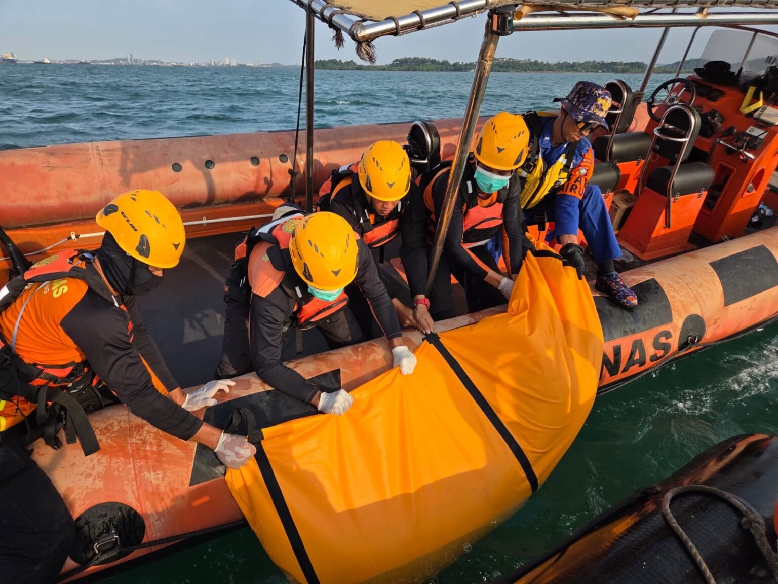 Tim SAR Gabungan saat melakukan evakuasi tubuh Sakaria Jerianto (23 th), korban yang diduga terjatuh dari kapal Tamark 02 di wilayah perairan Tanjung Pinggir, Kota Batam, Provinsi Kepulauan Riau, Minggu (18/01/2026)