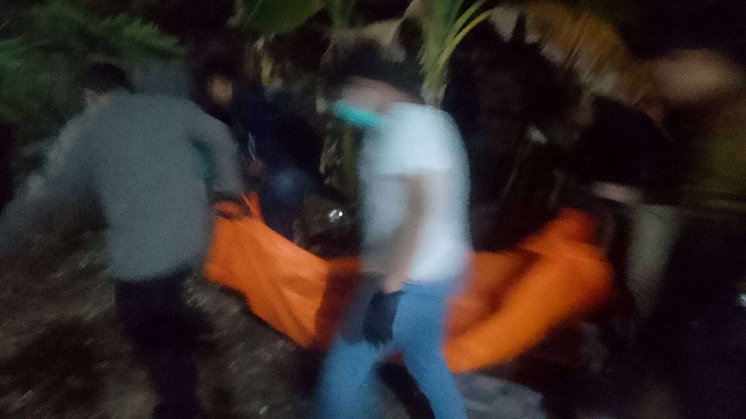 Petugas kepolisian saat melakukan evakuasi mayat korban wanita