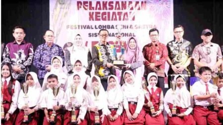 Wakil Walikota Tanjungpinang Raja Ariza menyerahkan piala pemenang juara umum FLS3N jenjang SD dan SMP di Gedung Aisyah Sulaiman, Kamis (21/5).