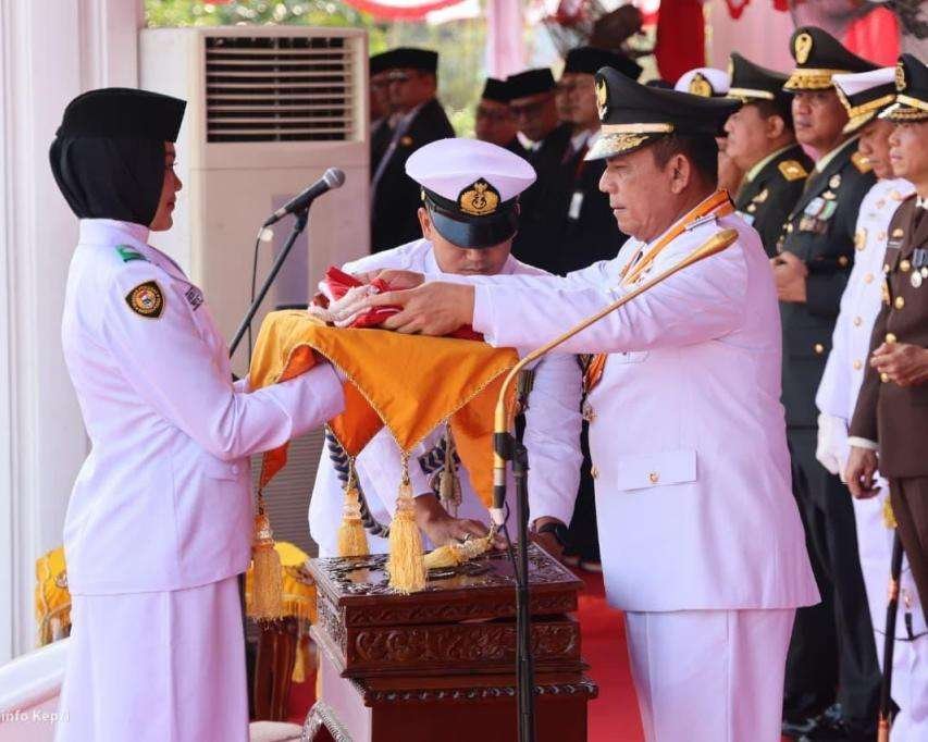 Pimpin Upacara HUT ke-81 RI di Gedung Daerah, Ansar Tekankan Peran Kepri sebagai Perisai Kedaulatan Maritim Indonesia Gubernur Kepri Ansar Ahmad menyerahkan Bendera Merah Putih kepada Yuanita Putri Verinda, pembawa baki Paskibraka dalam Upacara Peringatan HUT ke-81 RI di Gedung Daerah, Senin (17/8)